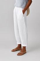 Close-up detail of the breathable linen-cotton fabric texture on the Kallista trousers in a serene white.