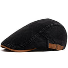 A lifestyle shot of the premium denim flat cap placed on a café table, suggesting a relaxed, urban setting.