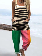 Front view of the Kiana bold pattern jumpsuit, showcasing the zebra print top, vibrant green left leg, and pink right leg with yellow accent.