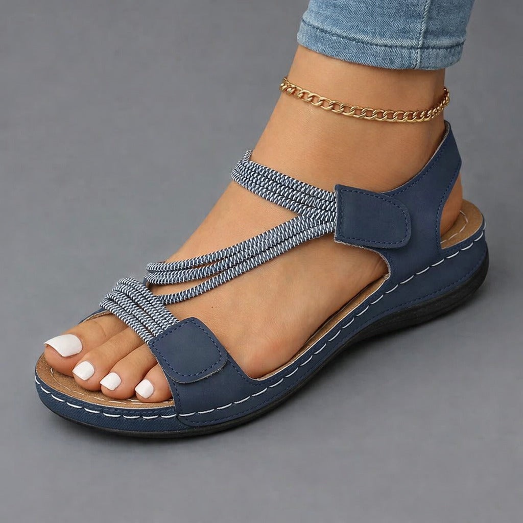 Lifestyle image of Liana orthopedic comfort sandals in various colors neatly arranged on a wooden deck, suggesting relaxation and outdoor versatility.