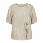 Close-up detail of the raised circular embroidery on the Calliope casual top, highlighting its intricate texture.