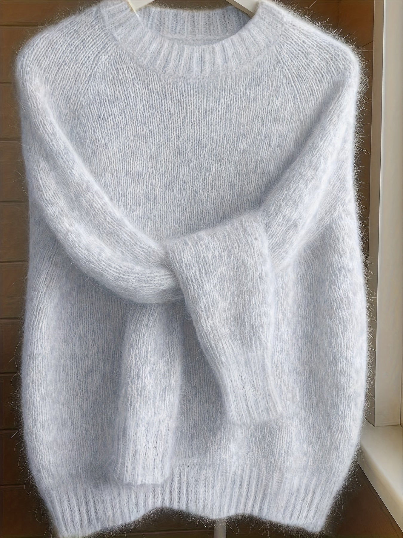 Side profile of a model wearing the light grey Lila cashmere-blend sweater, highlighting its flattering fit.