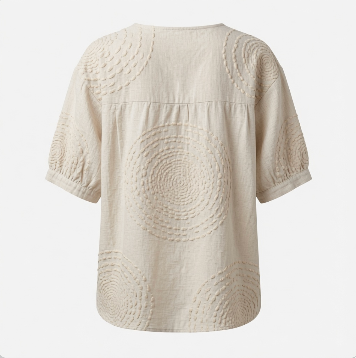 Overhead flat lay of the Calliope embroidered casual top, emphasizing the fabric quality and unique button placket.