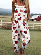 Front view of the Elara ladybug and floral print jumpsuit, showcasing its relaxed fit and white fabric with red and green patterns.