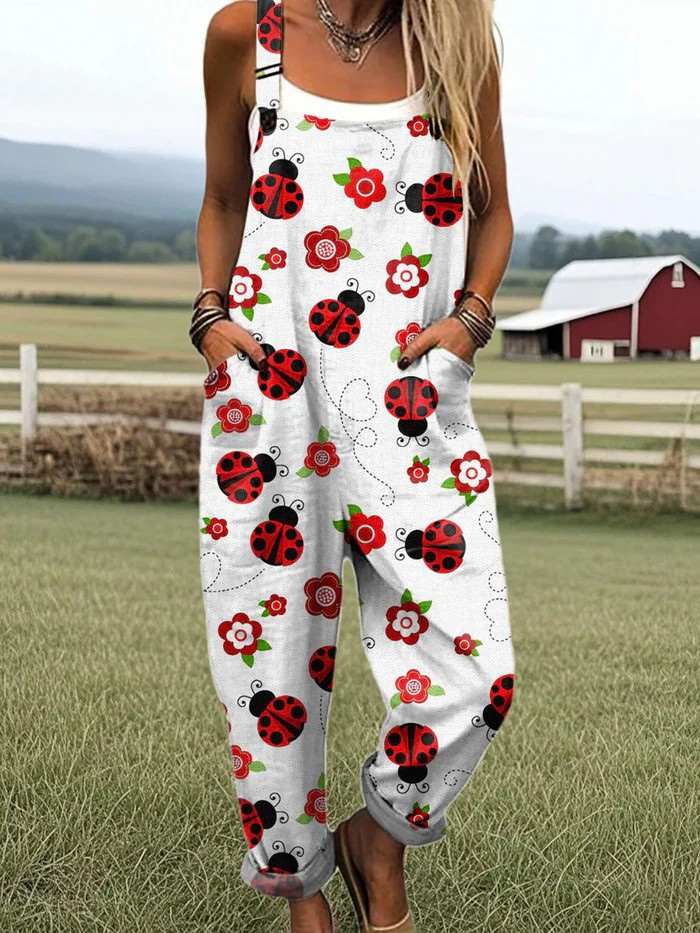 Front view of the Elara ladybug and floral print jumpsuit, showcasing its relaxed fit and white fabric with red and green patterns.