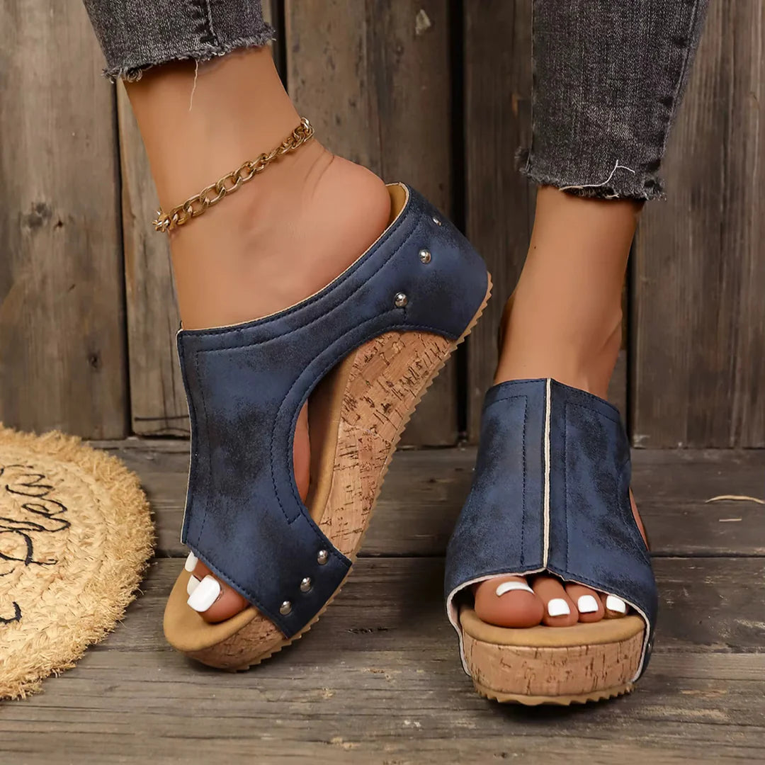 A model wearing the khaki Marlowe studded wedge sandals, captured in a full-body shot, showcasing their versatile styling potential.