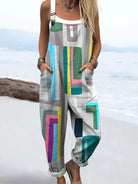 A full-body view of a woman wearing the Paloma geometric colorblock jumpsuit, showcasing its vibrant pattern and relaxed fit from a front angle.
