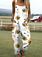 Front view of the Juniper Jumpsuit, a white overall adorned with a delightful pattern of yellow bees, red hearts, and vibrant sunflowers, showcasing its relaxed fit and rolled cuff hem.