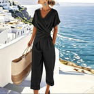 Full-body shot of a woman wearing the black refined two-piece outfit, styled for an evening event, showing its versatility.