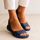 Woman wearing white Zara open-toe non-slip sandals, walking on a paved path, illustrating comfortable movement.